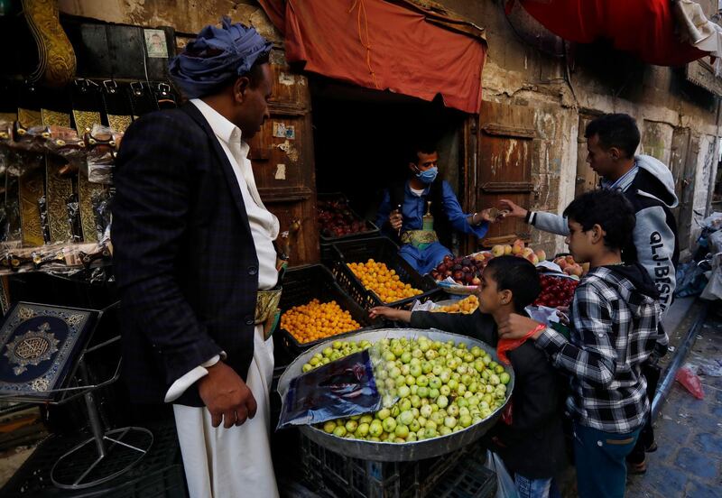 epa08413498 A Yemeni vendor (C) wearing a protective face mask sells fruits at a market amid the ongoing coronavirus COVID-19 pandemic, in Sanaa, Yemen, 10 May 2020. According to reports, the World Health Organization (WHO)'s staff activity has been suspended in the Houthi-controlled northern part of Yemen, including the capital Sanaa, amid concerns over the ongoing coronavirus which causes the COVID-19 disease.  EPA/YAHYA ARHAB