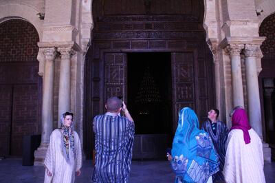 Tourists dressed in traditional Tunisian gowns visiting the holy Okba Grand Mosque in Kairouan. Ghaya Ben Mbarek / The National