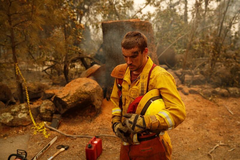 Shawn Slack rests after felling trees burned in the Camp Fire in Paradise. AP Photo