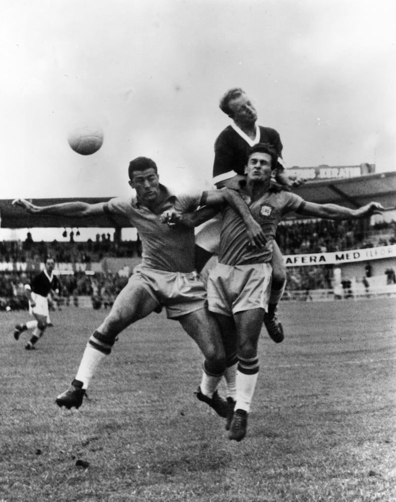 Ivor Allchurch of Wales competes for the ball against Hideraldo Bellini and Nilton De Sordi of Brazil during the quarter final. 