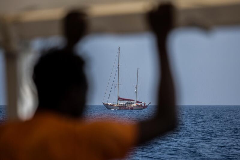 A migrant standing on the deck of the NGO Proactiva Open Arms boat looks at the Open Arms Astral sailboat on July 2, 2018. A Spanish NGO said on June 30, 2018 it had rescued 59 migrants as they tried to cross the Mediterranean from Libya and would dock in Barcelona in Spain after Italy and Malta refused access. The news comes two days after three babies were found dead and 100 more went missing in a shipwreck off Libya that Proactiva Open Arms, whose charity rescue boat was in the area, said could potentially have been avoided.
 - 
 / AFP / Olmo Calvo
