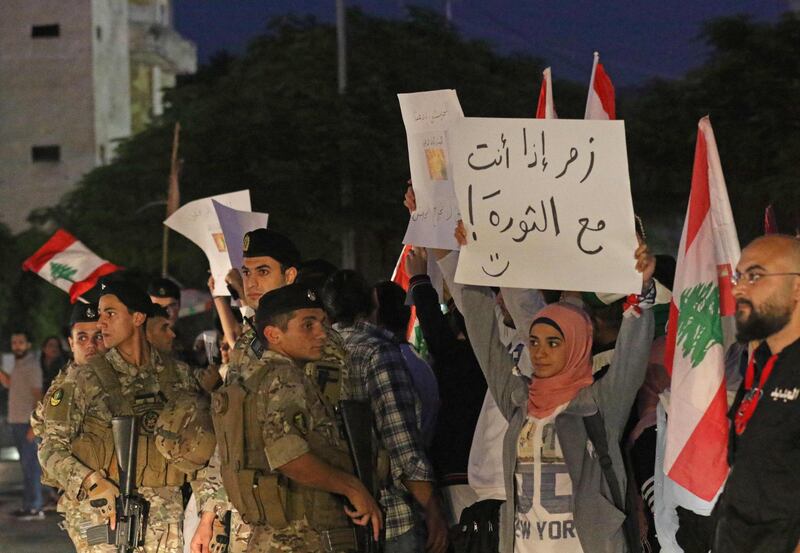 A Lebanese protester holds a placard reading "Honk if you support the revolution" in Sidon (Saida).  AFP