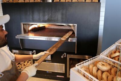 Putting bagels in the on-site wood-fired oven at Bagel Yard