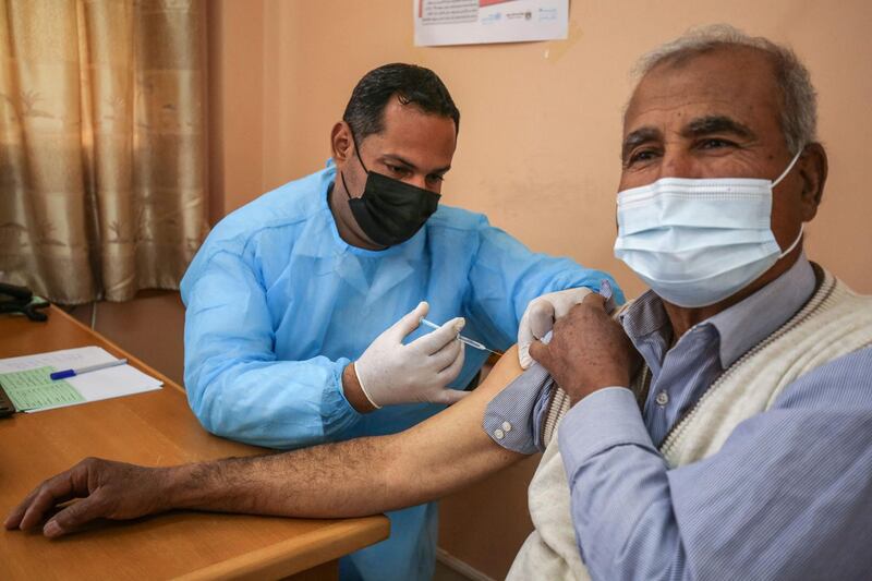 An employee of the United Nations Relief and Works Agency for Palestine Refugees (UNRWA) administers a shot of the Sputnik V COVID-19 vaccine at the UNRWA clininc in the Rafah camp for Palestinian refugees in the southern Gaza Strip, on March 3, 2021. / AFP / SAID KHATIB
