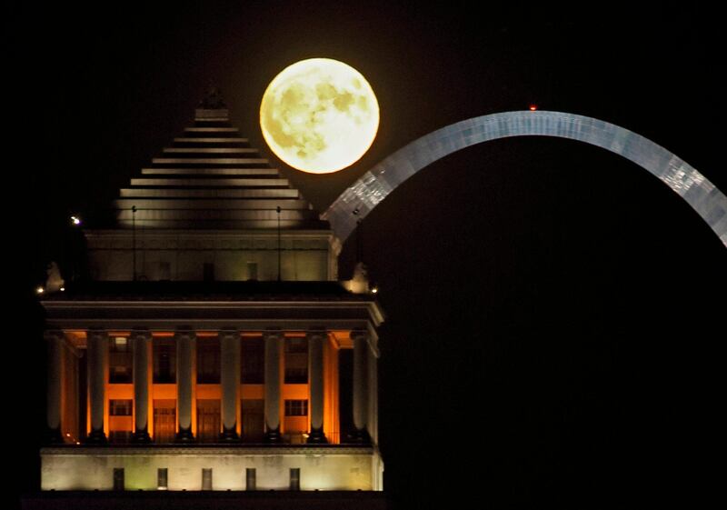 The harvest moon rises over the St Louis, US, skyline and the Arch.  AP