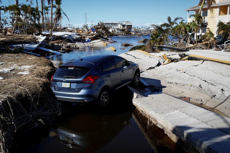 A car on a destroyed road between Matlacha and Pine Island after Hurricane Ian. Reuters