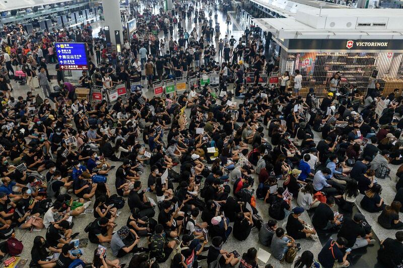 Hong Kong pro-democracy protesters (bottom) block access to the departure gates during another demonstration at Hong Kong's international airport on August 13, 2019.  AFP