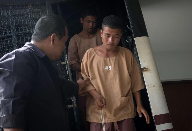 Myanmar national Zaw Lin, front centre, arriving in a prison transport van outside Koh Samui courthouse as fellow suspect Win Zaw Tun, top centre, follows on at the Thai resort island of Koh Samui on July 9, 2015. The high-profile trial of the two Myanmar migrants charged with killing two British holidaymakers is under way. Jerome Taylor/AFP Photo