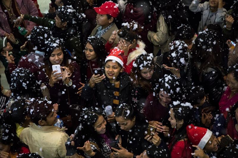 Nepalese youths play with fake snow during an event on Christmas Day in Kathmandu, Nepal. EPA/Hemanta Shrestha