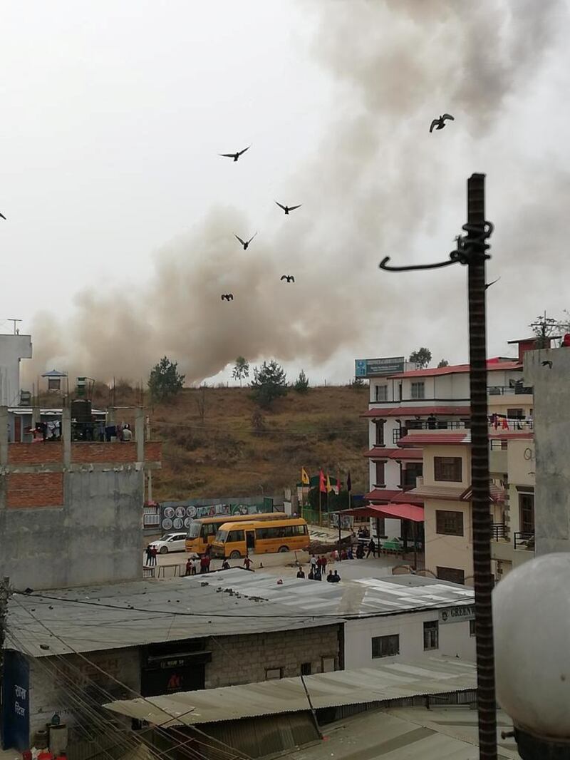 Smoke rises following the crash of a Bangladeshi aircraft at Kathmandu airport, Nepal. Rusha Giri / via Reuters