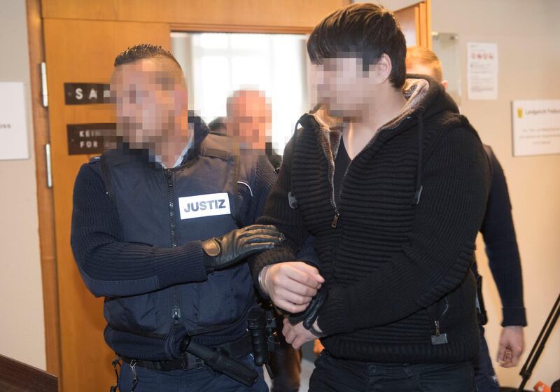 Defendant Hussein K (R) is led out of the court room after beeing sentenced for life imprisonment at the regional court in Freiburg, southern Germany, on March 22, 2018.
The asylum seeker claiming to be from Afghanistan was sentenced to life in jail for the rape and murder of a student that stoked public fears and a backlash against a mass influx of migrants. / AFP PHOTO / THOMAS KIENZLE / GERMAN COURT REQUESTS THAT THE FACES OF THE DEFENDANT AND OF JUDICIAL OFFICERS MUST BE MADE UNRECOGNISABLES