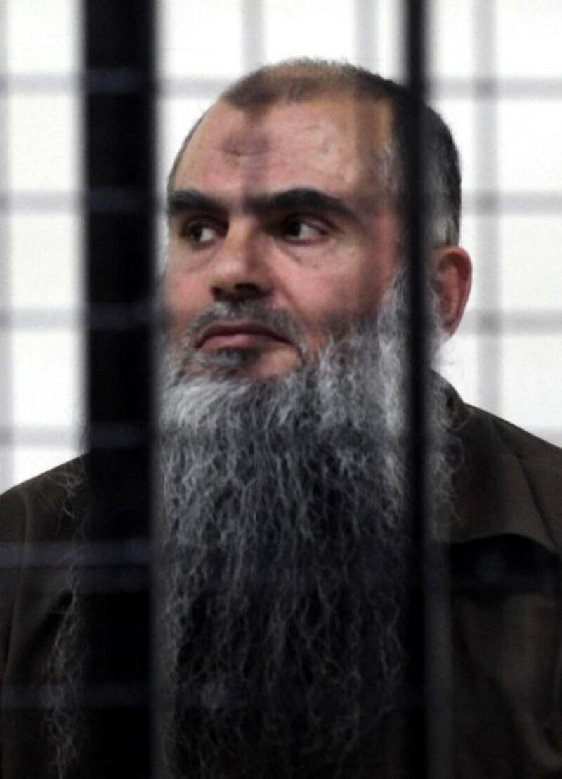  Cleric Abu Qatada looks on from behind the bars at the state security court in Amman during a hearing in his case on June 26, 2014. The court acquitted the cleric, who was deported from Britain last July after a 10-year legal battle, of charges of conspiring to commit acts of terrorism. AFP Photo

