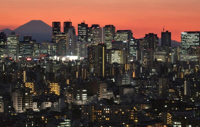 This photo taken on January 4, 2017 shows skyscrapers in Tokyo's Shinjuku area lit up at dusk in front of Mount Fuji.
Tokyo and its surrounding areas sit precariously at the junction of shifting tectonic plates and have suffered violent quakes in the past, notably the 1923 Great Kanto Earthquake that killed more than 100,000 people. / AFP PHOTO / KAZUHIRO NOGI / TO GO WITH Oly-2020-JPN-disaster,FOCUS by Shingo ITO