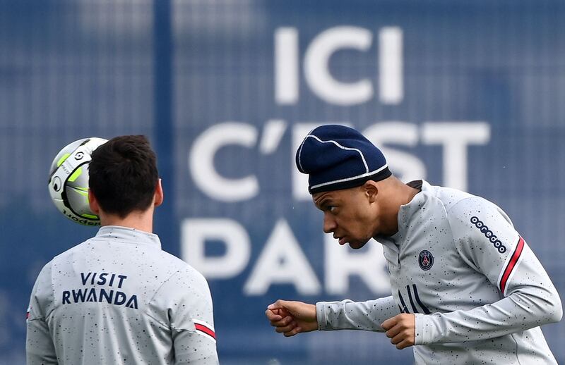 Paris Saint-Germain's French forward Kylian Mbappe (R) heads the ball during a training session at the club's Camp des Loges training ground in Saint-Germain-en-Laye, west of Paris, on April 28, 2022.  (Photo by FRANCK FIFE  /  AFP)