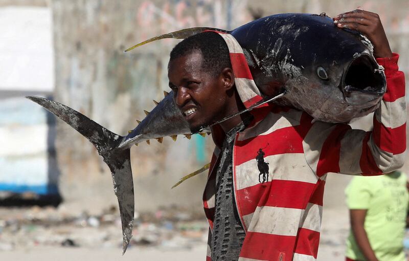 A man carries a huge fish across his shoulders at Liido beach in Mogadishu, Somalia. Reuters