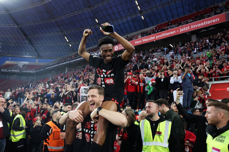 Nathan Tella of Bayer Leverkusen is hoisted up by fans after their Bundesliga title win. Getty Images 