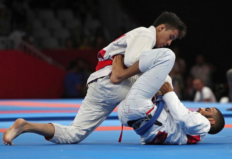 Akmal Amirov of Uzbekistan, top, competes with Hamad Nawad of United Arab Emirates, bottom, during newaza men's - 56 kilogram jujitsu at the 18th Asian Games in Jakarta. AP