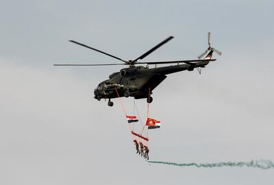 A military helicopter flies with Iraqi special forces soldiers hanging onto a rope and displaying Iraqi flags in Baghdad, Iraq April 6, 2021. REUTERS/Khalid al-Mousily