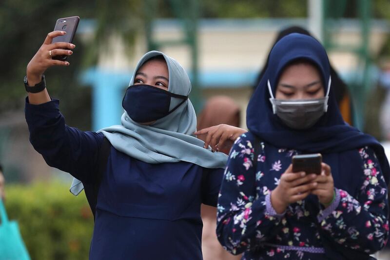 A Muslim woman takes a selfie after Eid Al Adha prayers at a mosque in Jakarta, Indonesia. AP Photo