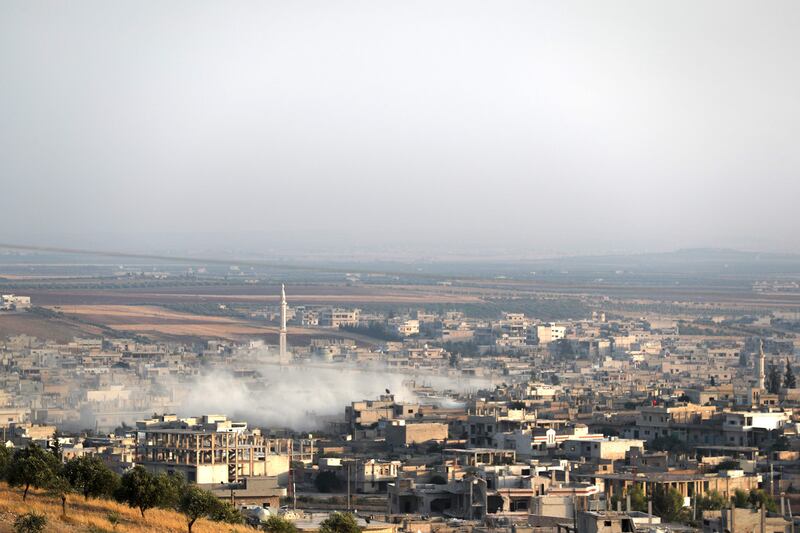 This picture taken on August 5, 2019 shows smoke billowing above buildings during a reported air strike by pro-regime forces on Khan Sheikhun in the south of the northwestern Syrian province of Idlib. Damascus and Russia resumed air strikes on Idlib in northwest Syria on August 5, a monitor said, scrapping a ceasefire for the jihadist-run bastion and accusing the regime's opponents of targeting a Russian air base. The northwestern region, which hosts some three million people, is one of the last major centres of resistance to President Bashar al-Assad's regime after eight years of war. / AFP / Omar HAJ KADOUR

