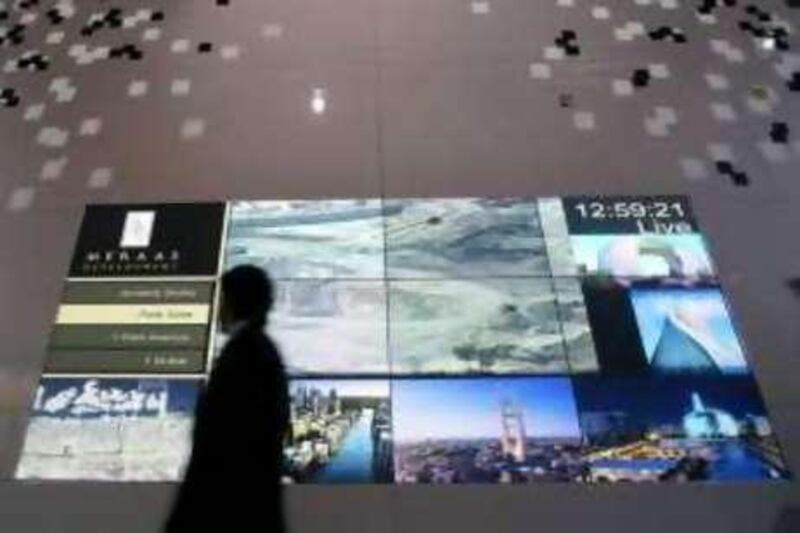 Dubai, UAE - October 9, 2008 -  A man walks past a projection of Meraas Developement projects at Cityscape Dubai at the Dubai International Exhibition Center. (Nicole Hill / The National) *** Local Caption ***  NHCityscape07.jpgNHCityscape07.jpg