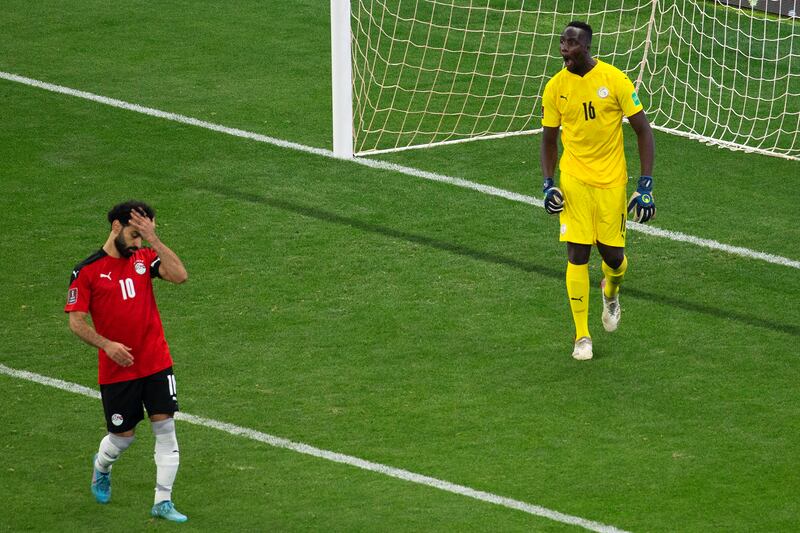 Egypt's Mohamed Salah after missing in the shoot-out while Senegal goalkeeper Edouard Mendy celebrates. AP
