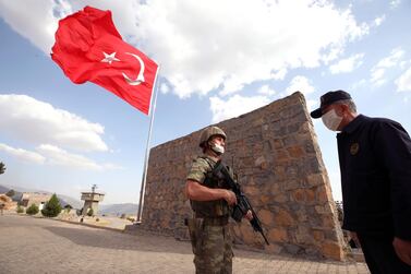 Turkey's Defence Minister Hulusi Akar speaks to a soldier while visiting Turkish troops on the border with Iraq. AP
