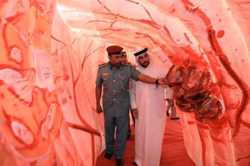 21July 2010 - Abu Dhabi - Ayman Kamel Ibrahim, Security Officer of Health Authority of Abu Dhabi and Sami Zayed Al Monzeui, community police officer, walks through a replica Colon replica at the reception at Abu Dhabi Health Authority. Ravindranath K / The National