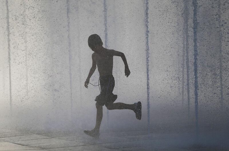 A boy playing in a fountain to cool off during a heatwave in Shenyang in China's northeastern Liaoning province. AFP