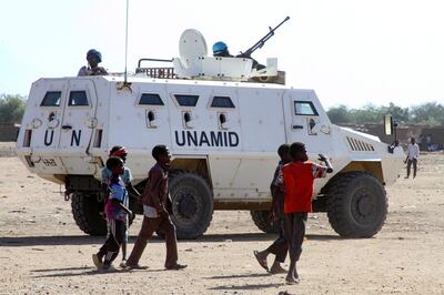 Sudanese children walk past an armoured vehicle of the United Nations and African Union peacekeeping mission (UNAMID) in Kalma Camp for internally displaced people in Nyala, the capital of South Darfur, on December 30, 2020.  The United Nations Security Council has agreed to end the UNAMID's long-running peacekeeping mission in Darfur when its mandate ceases on December 31.
The withdrawal of UNAMID, deployed since 2007 and which had 16,000 peacekeepers at its peak, will begin January 1 and is expected to be completed by June 30 2021.
 / AFP / -
