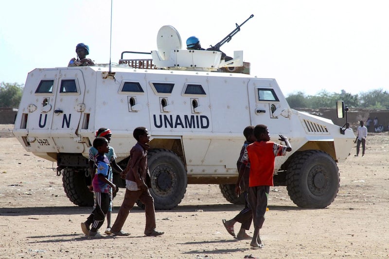 Sudanese children walk past an armoured vehicle of the United Nations and African Union peacekeeping mission (UNAMID) in Kalma Camp for internally displaced people in Nyala, the capital of South Darfur, on December 30, 2020.  The United Nations Security Council has agreed to end the UNAMID's long-running peacekeeping mission in Darfur when its mandate ceases on December 31.
The withdrawal of UNAMID, deployed since 2007 and which had 16,000 peacekeepers at its peak, will begin January 1 and is expected to be completed by June 30 2021.
 / AFP / -
