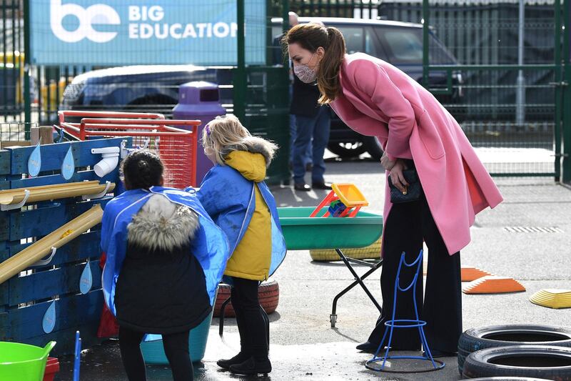 The Duchess of Cambridge talks with children in the water area of the playground. AP Photo