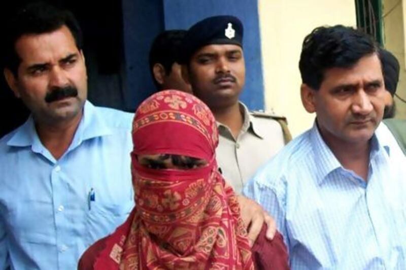 Indian police officials escort a 19-year-old man from a court appearance in Lakhisarai District.