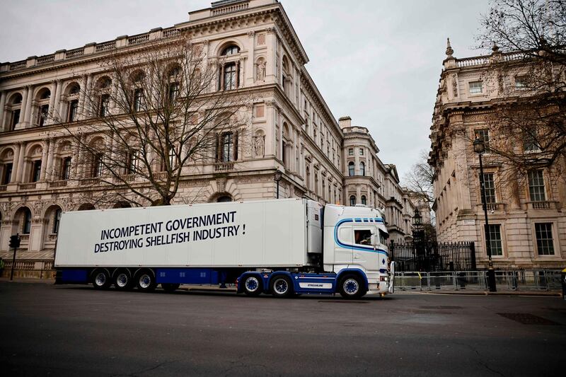 A lorry drives past Downing Street with a message that reads "Incompentent government destroying shellfish industry" in a protest action by Scottish fishermen in London. AFP