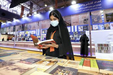 A visitor to Sharjah International Book Fair reads a book. Chris Whiteoak / The National