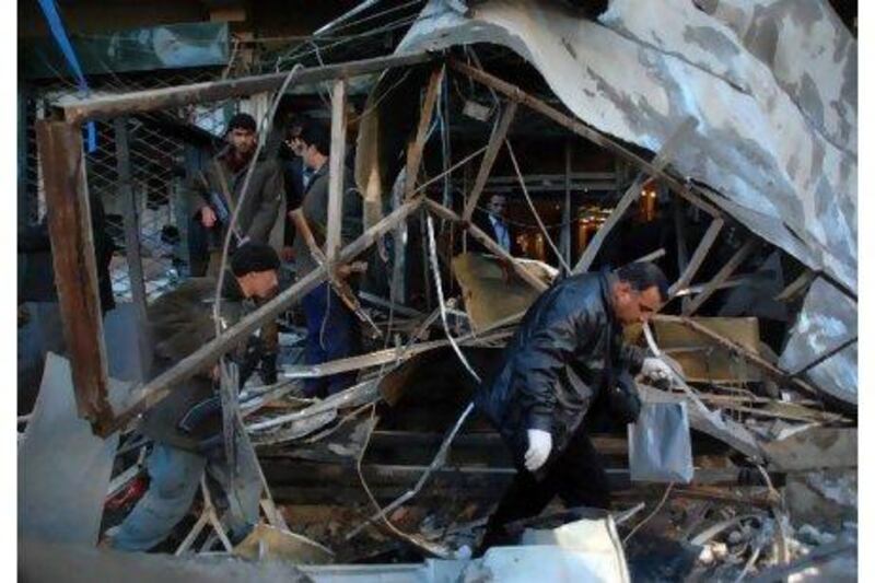 Afghan security men collect evidence after this week's shopping mall blast in Kabul. Three people died.