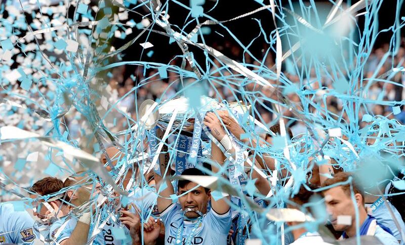 Manchester City’s Sergio Aguero, centre, lifts the English Premier League trophy after his team beat West Ham United on Sunday night at Etihad Stadium. It was the second league title in three years for Manchester City. Andy Rain / EPA