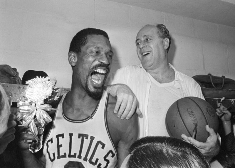 Boston Celtics' Bill Russell, left, holds a corsage sent to the dressing room as he celebrates with Celtics coach Red Auerbach after defeating the Los Angeles Lakers to win their eighth-straight NBA Championship. AP