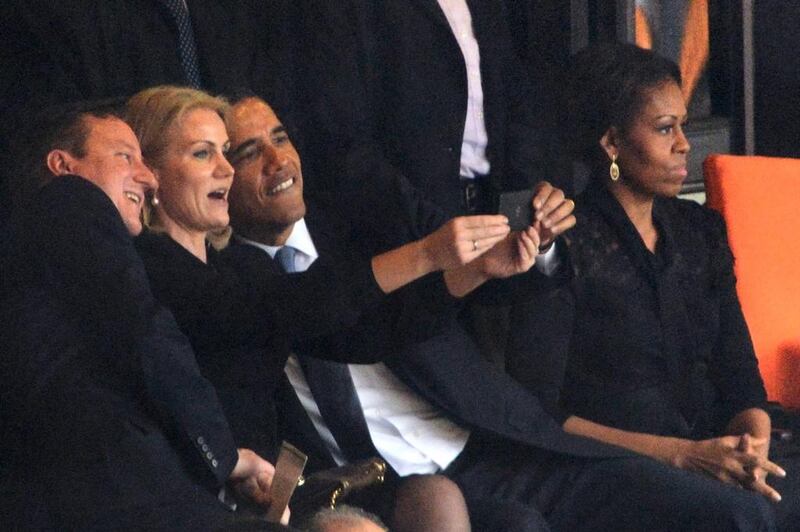 US President Barack Obama (right) and British Prime Minister David Cameron pose for a selfie with Denmark's Prime Minister Helle Thorning Schmidt (centre) as US First Lady Michelle Obama follows late South African president Nelson Mandela’s memorial service. Roberto Schmidt / AFP





