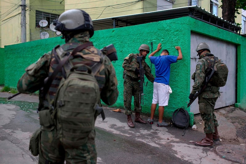 (FILES) In this file photo taken on February 07, 2018 Brazilian Army soldiers frisk a resident during a joint operation at "Cidade de Deus" (City of God) favela in Rio de Janeiro, Brazil.
According to matching sources on February 16, 2018 Brazilian President Michel Temer will decreet an Armed Forces' intervention in the Brazilian state of Rio de Janeiro to take the lead in the fight against organised crime.  / AFP PHOTO / MAURO PIMENTEL