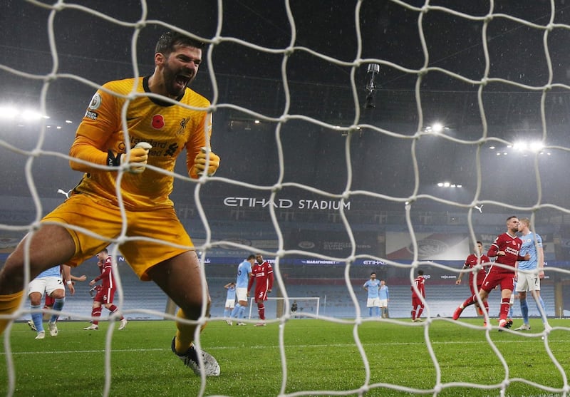 Liverpool goalkeeper Alisson celebrates after City's Kevin De Bruyne misses a penalty. Reuters