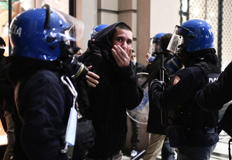 Italian police officers detain an activist in downtown Turin. AFP