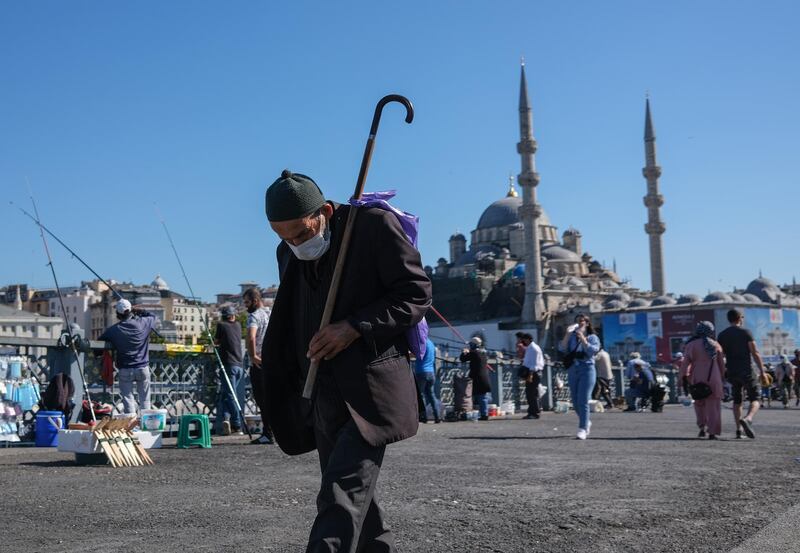 An elderly man walks on the Galata Bridge amid the ongoing coronavirus pandemic, in Istanbul, Turkey.  EPA
