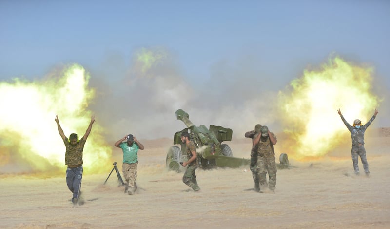 Popular Mobilisation Forces (PMF) personnel fire artillery rounds. Reuters