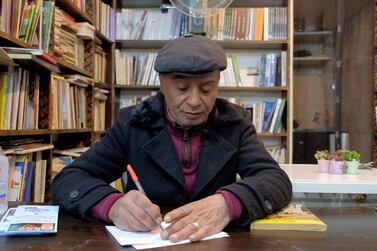 Hussein Yassin, owner of Azbekeye bookshop, holds a copy of his own book. Amy McConaghy / The National