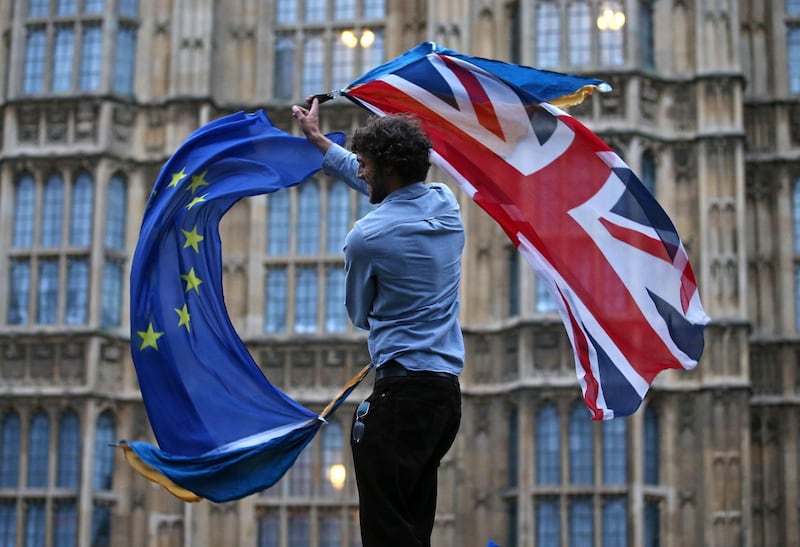 (FILES) In this file photo taken on June 28, 2016 a man waves both a Union flag and a European flag together on College Green outside The Houses of Parliament at an anti-Brexit protest in central London. Britain said on Thursday, December 24, 2020 an agreement had been secured on the country's future relationship with the European Union, after last-gasp talks just days before a cliff-edge deadline. / AFP / JUSTIN TALLIS
