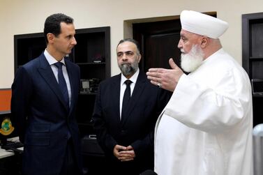 In this photo released on May, 20, 2019 by the Syrian official news agency SANA, shows Syrian President Bashar Assad, left, listens to Damascus Mufti Mohammed Adnan Afiouni, right, at an Islamic center, in Damascus, Syria. Afiouni who played a key role in government deals with rebel fighters, was killed on Thursday Oct. 22, 2020 by an explosion in the town of Qudsaya, west of Damascus, Syria, when a roadside bomb exploded near him, according to state media and a government site. (SANA via AP)