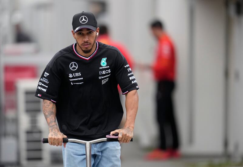 Mercedes driver Lewis Hamilton rides a scooter after the second practice session at the Japanese Grand Prix. EPA