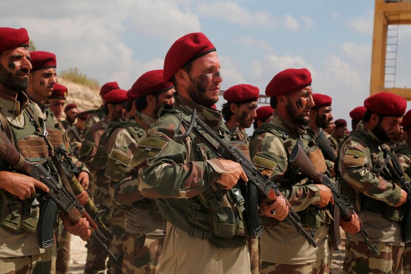 Turkish-backed forces from the Free Syrian Army, stand in formation during military maneuvers in preparation for an anticipated Turkish incursion targeting Syrian Kurdish fighters, near Azaz town, north Syria. AP Photo