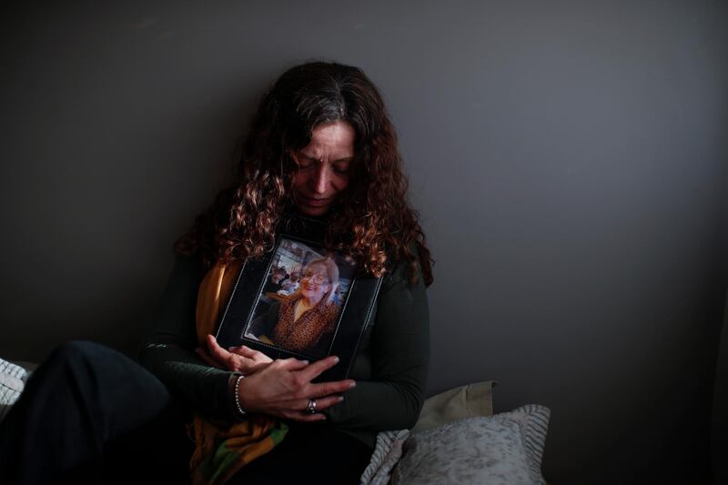 Fernanda Mariotti cradles a picture of her mother Martha Pedrotti, who died of Covid-19, at her home in Buenos Aires, Argentina. AP Photo